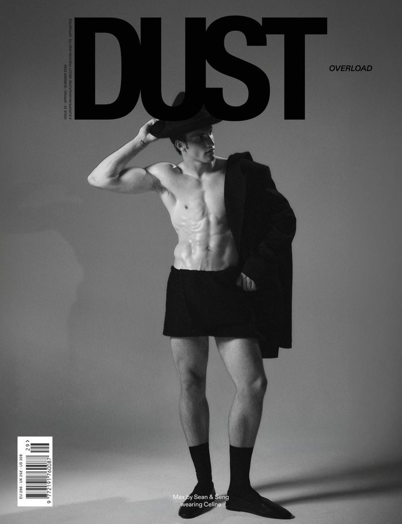 Monochrome magazine cover featuring a shirtless man wearing a hat, dark shorts, black socks, and shoes against a grey seamless background