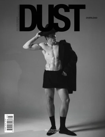 Monochrome magazine cover featuring a shirtless man wearing a hat, dark shorts, black socks, and shoes against a grey seamless background