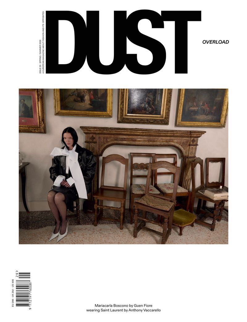 Mariacarla Boscono seated in an interior with wooden chairs and framed artwork for Dust Magazine
