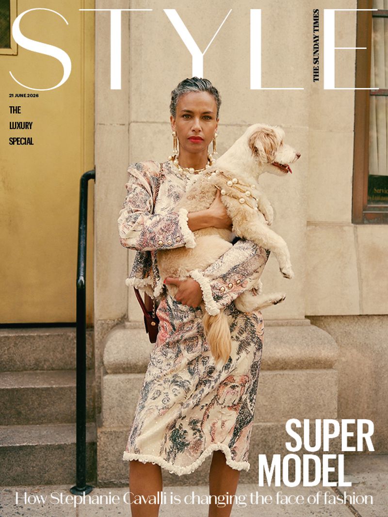 Model Stephanie Cavalli holding a fluffy dog while wearing a patterned fringe-trimmed suit on The Sunday Times Style cover.