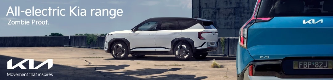 Two electric Kia SUVs are showcased outdoors with modern design and concrete surroundings, highlighting automotive innovation and sustainability.
