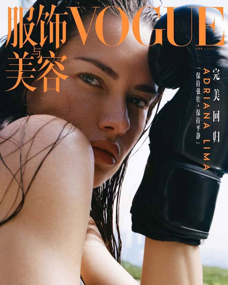 Close-up portrait of Adriana Lima on Vogue cover with boxing gloves, wet hair, and dramatic lighting. Beauty and fashion concept.