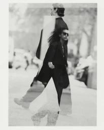 Monochrome multiple exposure image featuring two models wearing dark jackets walking outdoors on a city street