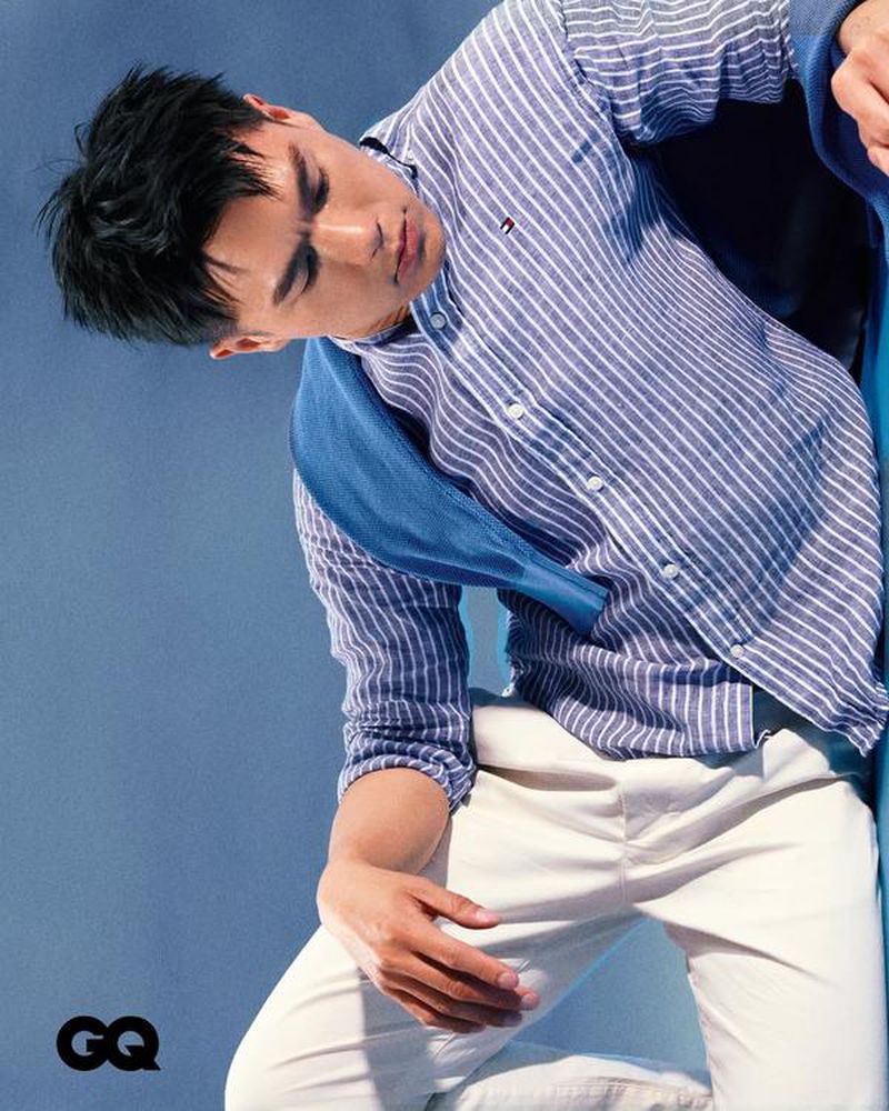Will Or wearing a blue and white striped shirt and white pants against a blue background for GQ Hong Kong.