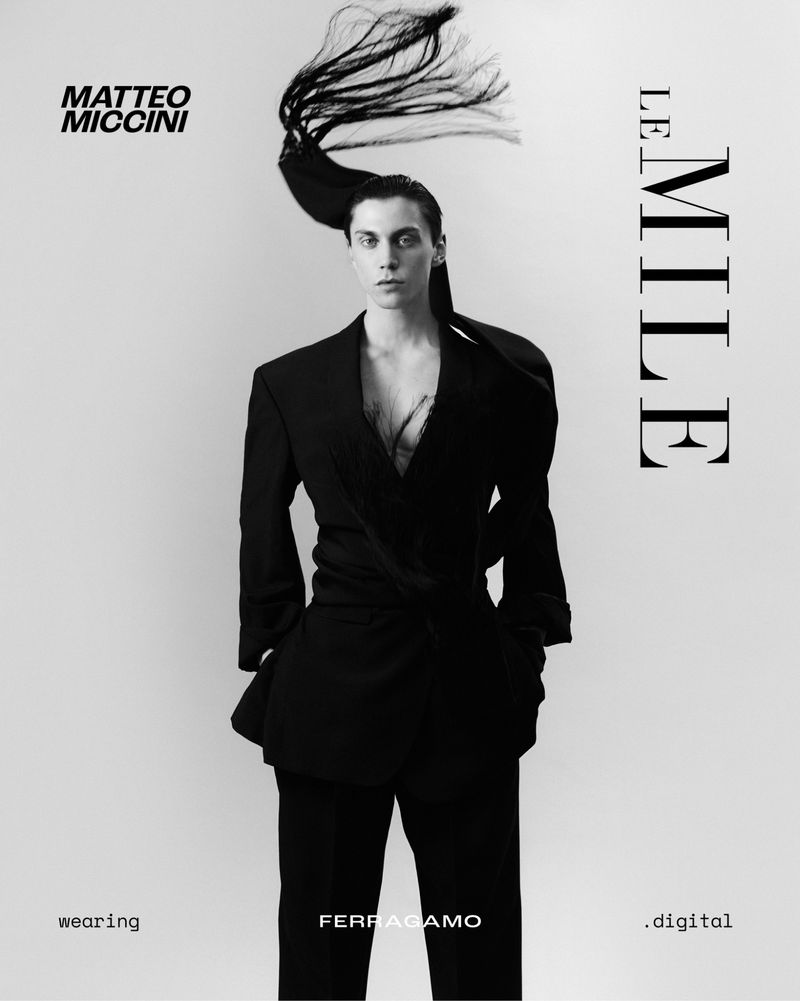 Model Matteo Miccini in a dark blazer with dynamic hair motion against a white background for Le Mile Magazine