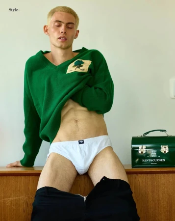Model Arnau Sarda posing in an emerald green sweater and white briefs against a neutral wall beside a vintage green box.