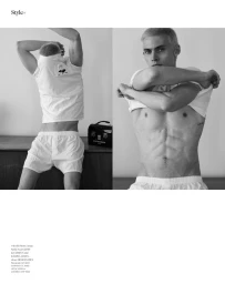 Black and white magazine spread of male model Arnau Sarda in a white t-shirt and white boxer shorts against a minimal wall.