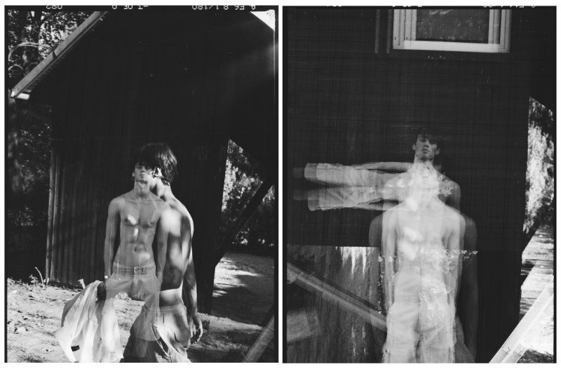 Black and white diptych photograph of a shirtless young man in layered double exposure poses near a wooden structure.
