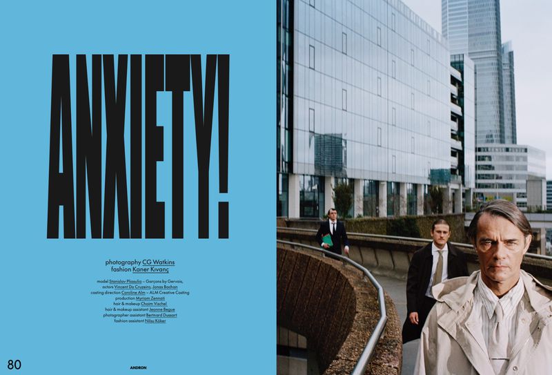 Editorial double-page spread featuring bold black text saying ANXIETY! on a blue panel next to three men walking outdoors near modern glass architecture.