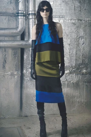 Model Svetlana Lethelier wears a colorblock blue, olive, and black dress with black leather gloves against silver foil insulation.