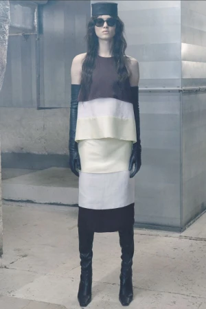 Model Svetlana Lethelier in a color-blocked layered dress with black leather opera gloves, boots, and hat for Christian Wijnants.