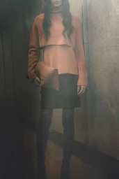 Model Svetlana Lethelier in a peach layered sweater, black skirt, and boots for Christian Wijnants Pre-Fall 2026.