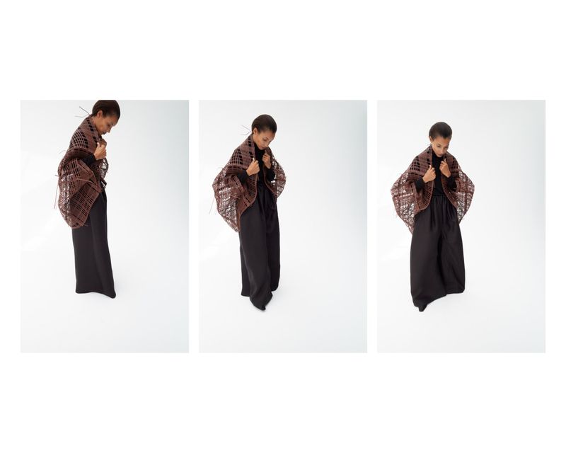 Triptych sequence of a model wearing a brown woven openwork shawl and wide-leg black trousers against a white background.