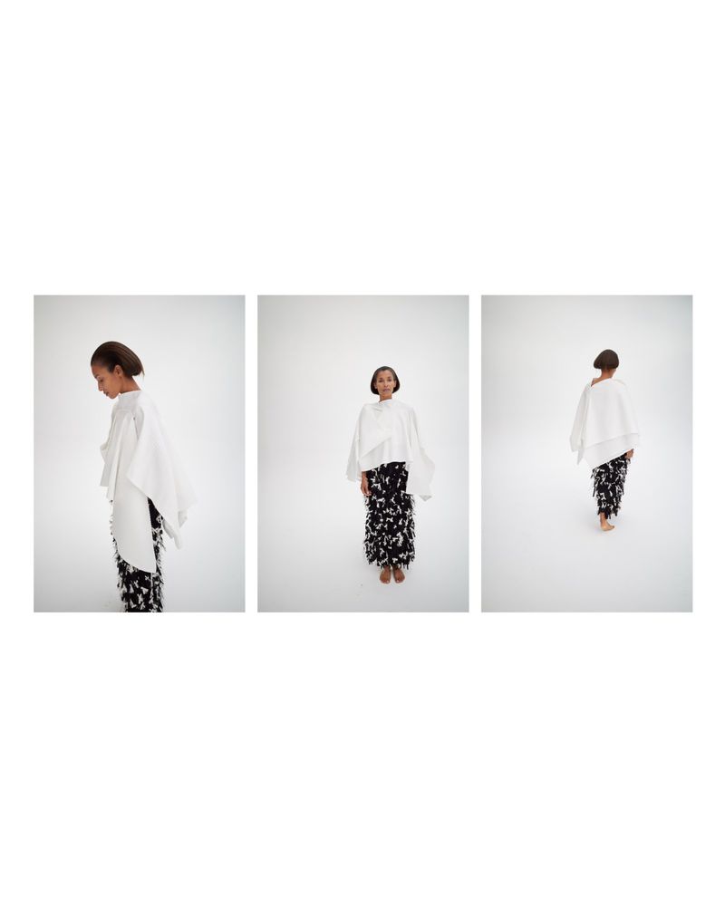 Triptych of model Romae Gordon in a white draped cape top and black and white patterned skirt on a white studio background.