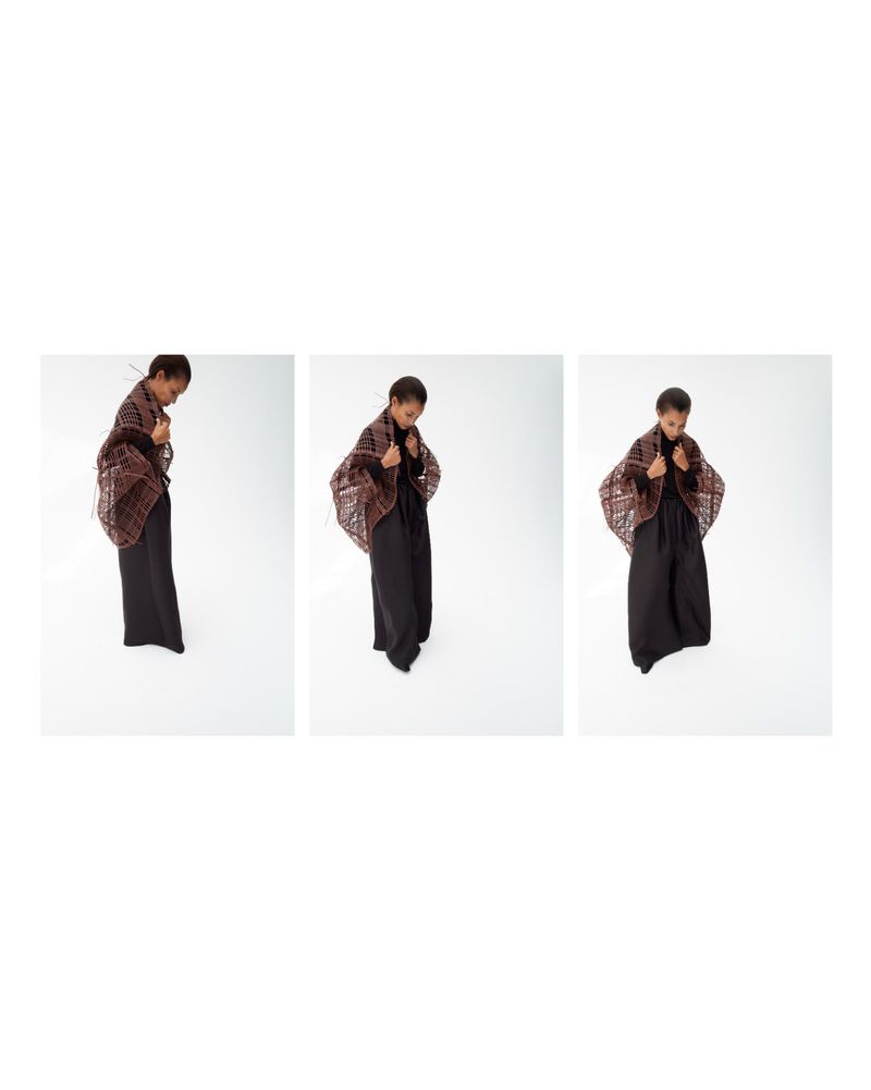 Triptych of a model wearing a brown patterned shawl and wide-leg black trousers against a white seamless studio background.