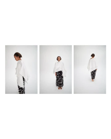 Triptych of model Romae Gordon in a white draped cape top and black and white patterned skirt on a white studio background.