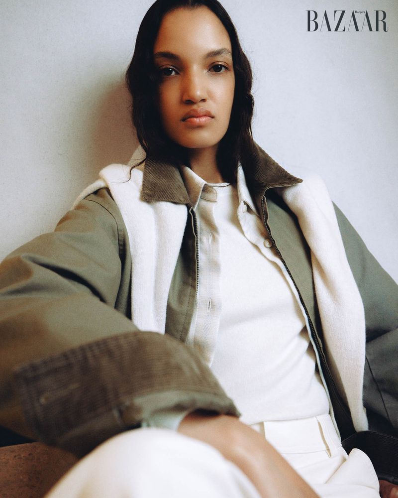 Model wearing an olive green jacket with corduroy trim layered over a cream top and white sweater for Harper's Bazaar Australia.