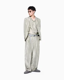 Model Ikko Ohira wearing a relaxed shimmering light grey suit and sunglasses against a seamless white studio background.