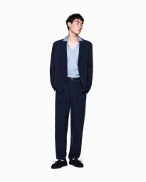 Model Ikko Ohira wearing a navy blue relaxed suit and light blue polo shirt against a plain white studio background.