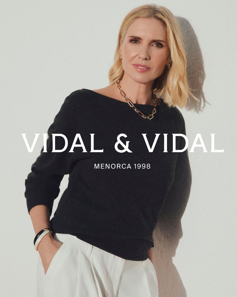 Model Judit Masco wearing gold link necklace and black top against a white seamless background for Vidal and Vidal campaign.
