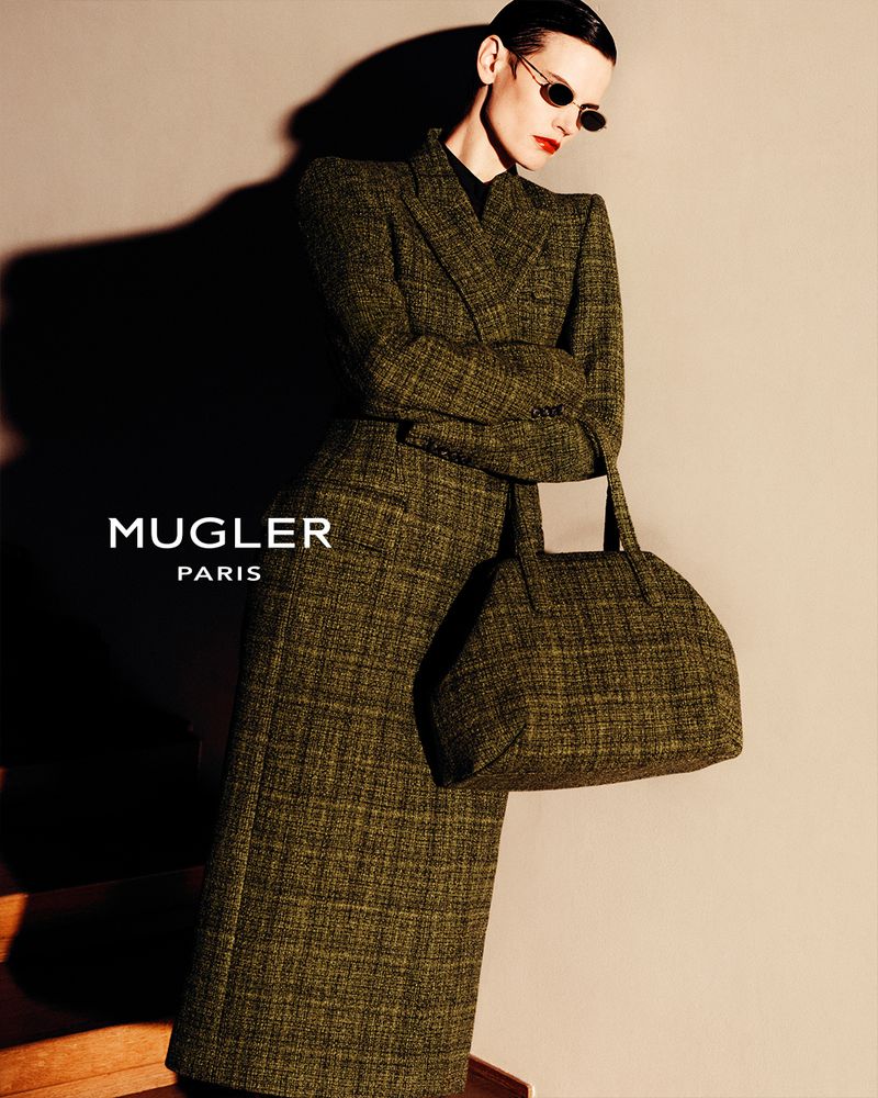 Saskia de Brauw wearing a tailored green tweed coat and matching handbag with dark sunglasses for Mugler.