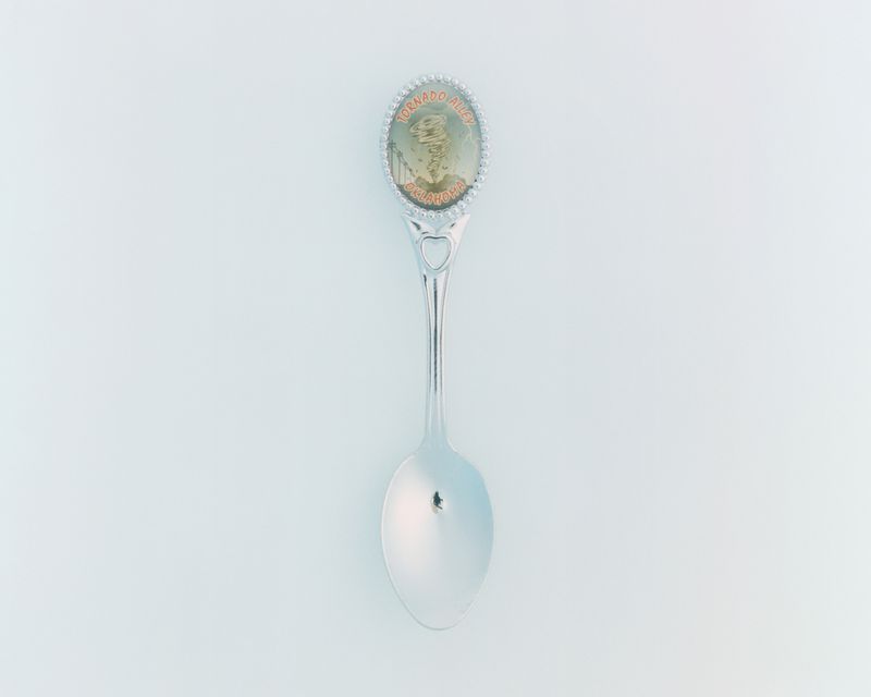 Silver collectible souvenir spoon featuring a Tornado Alley Oklahoma emblem centered against a plain white backdrop.