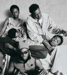 Monochrome editorial portrait of five Black male models styled in contemporary menswear posed closely together in a studio setting.