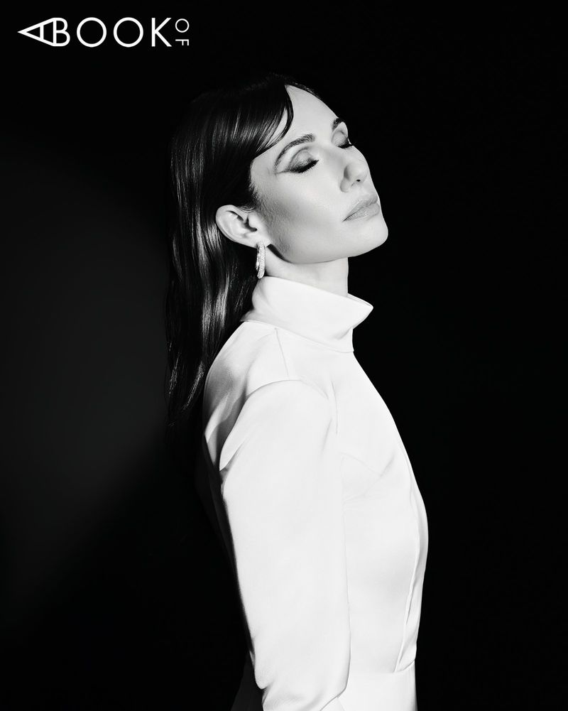 Black and white portrait of Jessica Blair Herman in a high-neck white top against a solid black background.