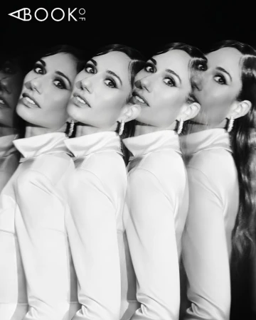 Jessica Blair Herman photographed with a repeating prism effect wearing a high-collar top and earrings in black and white.