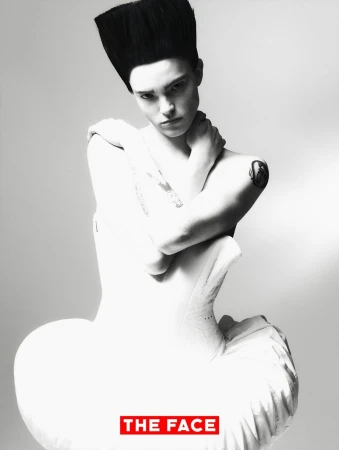 Model Malte Carlsson posing with crossed arms in a sculptural white corset dress and tall flattop hair for The Face China.