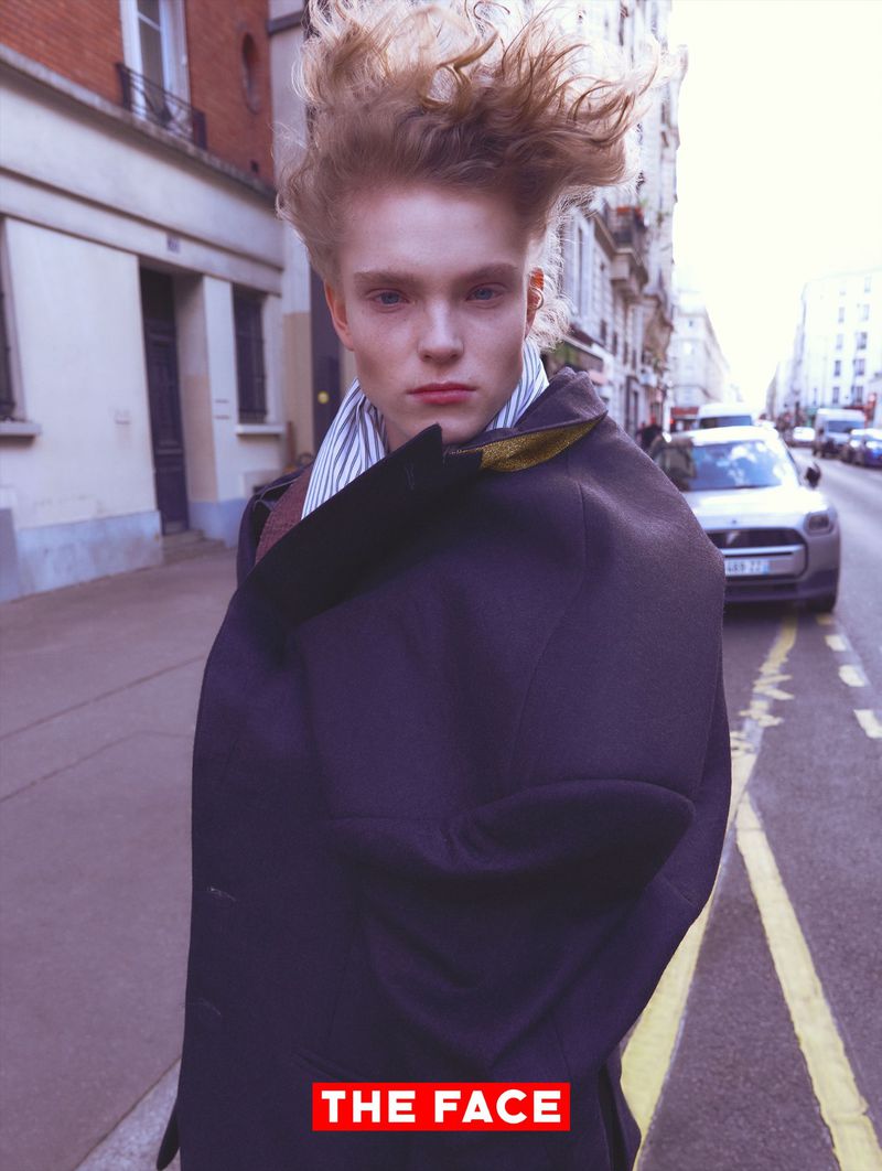 Model Malte Carlsson with swept blonde hair wearing an oversized dark coat on a city sidewalk for The Face China.