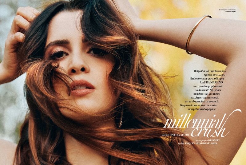 Close-up portrait of Laura Marano with windblown brunette hair and gold bracelet for InStyle Greece.