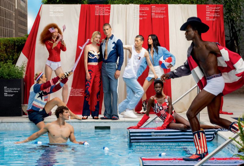 Models pose in red, white, and blue Americana fashion around an outdoor pool against a red-and-white draped striped backdrop.