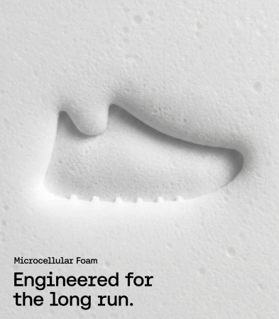 Debossed running shoe imprint in textured white microcellular foam with black marketing typography in the lower corner.