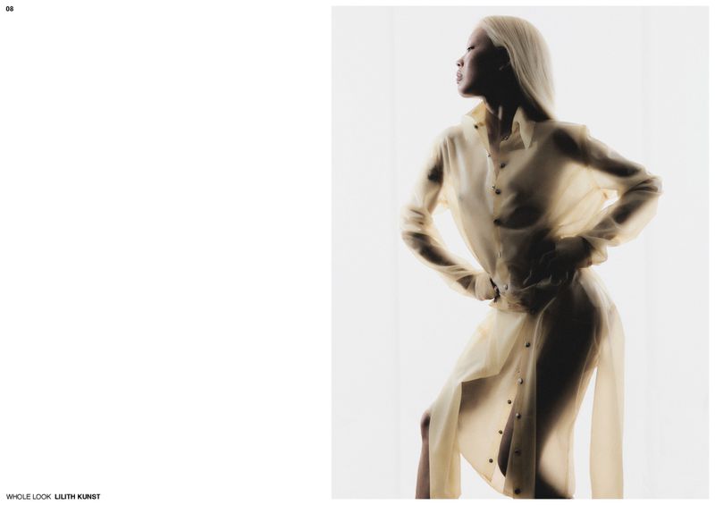 A blonde model wearing a translucent button-up shirt dress poses against a bright white background in an editorial spread.