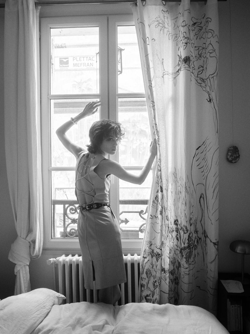 Model Gabrielle Rul poses by a window in a domestic bedroom for CAP 74024 editorial, photographed in monochrome.