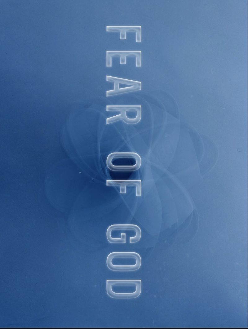 Fear of God brand name displayed in vertical translucent glowing lettering against a smooth deep blue gradient background.