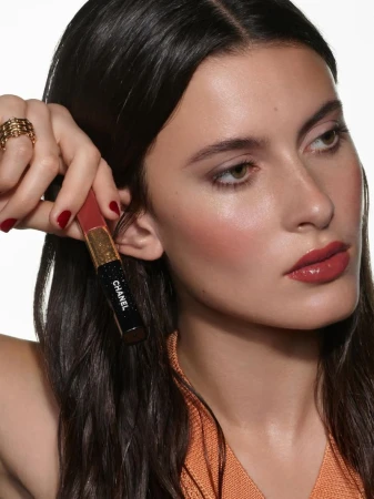 Model Lennon Sorrenti poses with Chanel Le Rouge Duo Ultra Tenue liquid lipstick against a bright white background.