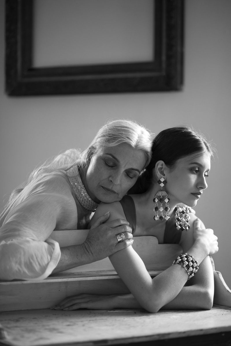 Black and white portrait of two women posing together in an interior setting with soft natural light.