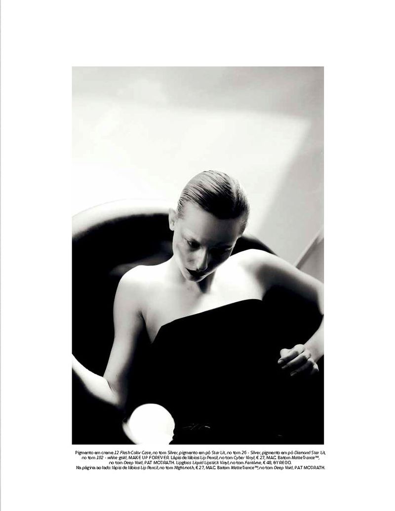 Model Melinda Kiss seated in a curved black chair wearing a strapless black top in a high-contrast black and white editorial frame.
