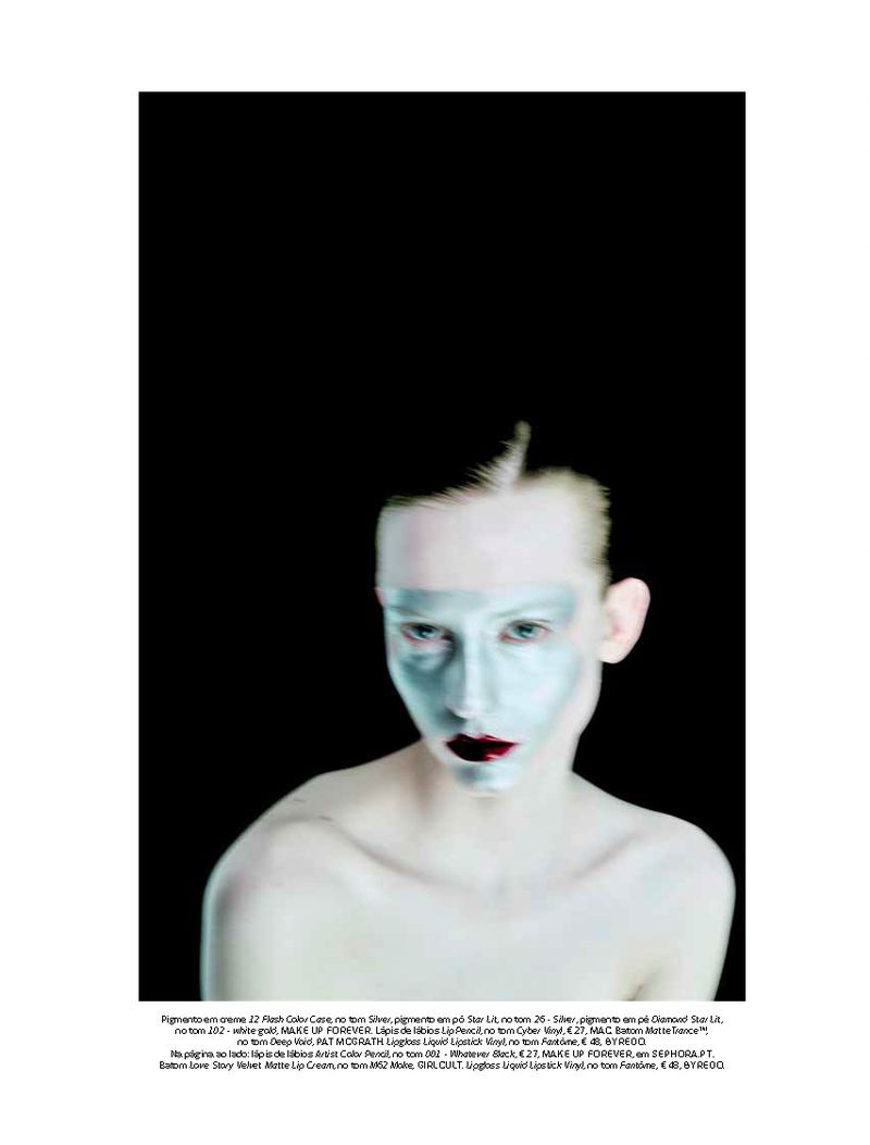 Model Melinda Kiss wearing metallic silver face paint and dark lipstick against a black background for Vogue Portugal.