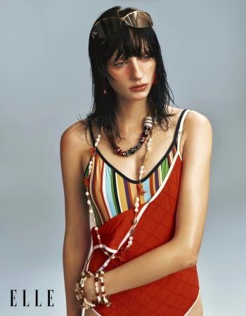 Model Hannah Vincent wearing layered swimwear and pearl bead necklaces against a pale studio backdrop for Elle China.