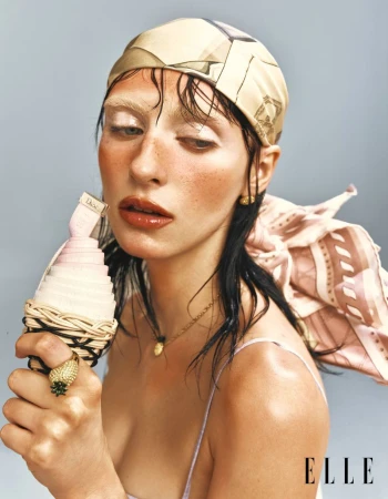 Model Hannah Vincent wearing a printed headscarf and holding a styled cone prop in an editorial for Elle China.