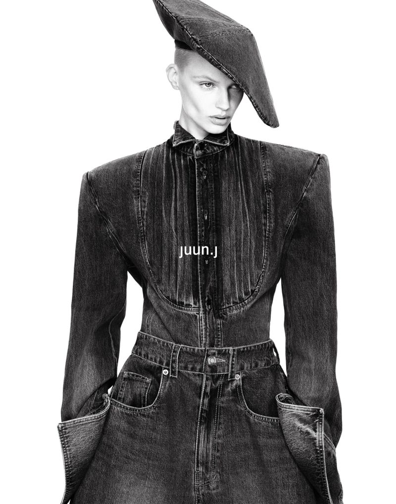 Model Mila van Eeten poses in a structured washed black denim outfit with exaggerated shoulders and a tilted denim beret.