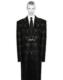 Model Mila van Eeten wearing an oversized black plaid tailored coat with a white shirt and black tie against a white backdrop.