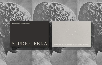 Two Studio Lekka business cards in black and light grey shown over a monochrome repeating classical sculpture background.