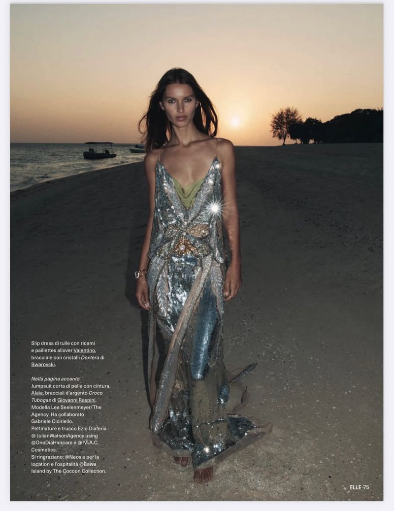 Model Lea Seelenmeyer posing on a sandy beach at sunset wearing an embellished silver sequin gown for Elle Italia.
