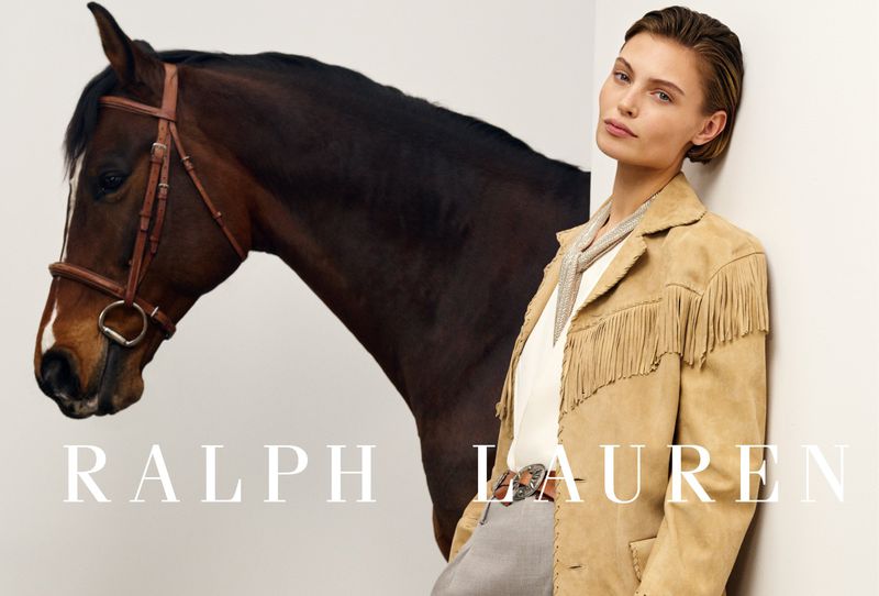 Fashion ad features a woman in a fringe jacket standing next to a horse, promoting Ralph Lauren with a neutral backdrop.