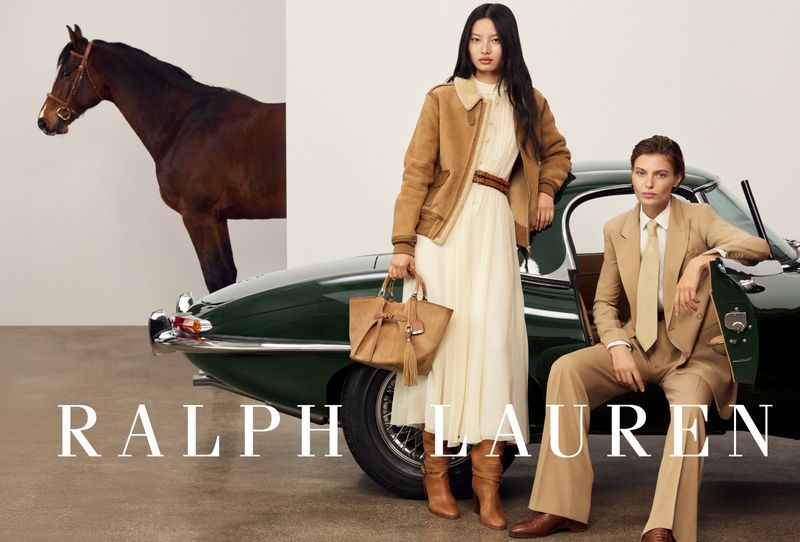 Fashion editorial featuring two women in tan outfits with a horse in the background and a dark green classic car. Ralph Lauren logo.
