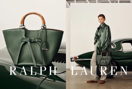 Model wearing a glossy green coat standing next to a vintage green car holding a green leather handbag with a bamboo handle